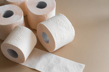 rolls of toilet paper peach beige color on beige background