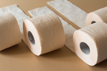 rolls of toilet paper peach beige color on beige background