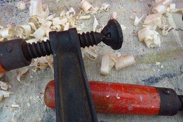 Old fashioned wood clamp on a workbench with wood shavings
