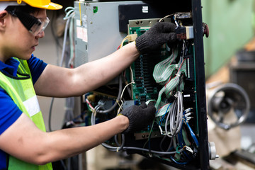 Electrician Engineers repairing machinery in industrial plants. worker Working at the Heavy Industry Manufacturing Facility.