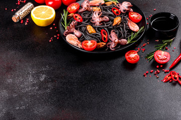 Black seafood pasta with shrimp, octopus and mussels on black background. Mediterranean gourmet food