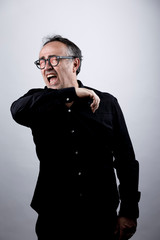 Obraz premium uomo in camicia nera con occhiali starnutisce e si ripara con il gomito, isolato su sfondo nero