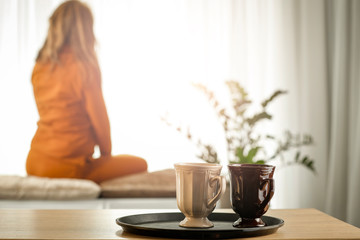 Woman by the window in the morning in the light of the sun