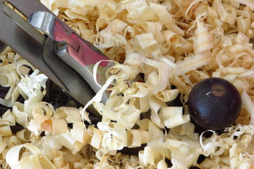 An old fashioned wood plane lies amongst the wood shavings it created.