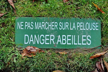 Panneau sur une pelouse: Ne pas marcher sur la pelouse. Danger abeilles.