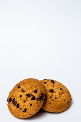 two homemade cookies with pieces of chocolate for breakfast lie on a white isolated background.