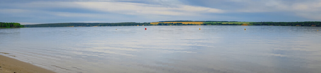 Panorama of a large river with a sandy Bank against a cloudy sky in evening