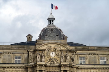 Fototapeta na wymiar Drapeau français sur le toit du Palais du Sénat. Jardins du Luxembourg. Paris.