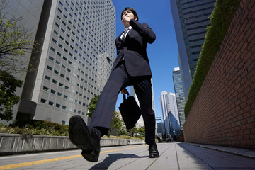 オフィス街を颯爽と歩く日本人男性ビジネスマン