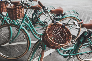 Parking with retro turquoise bike. Stylish bicycles with wicker baskets. Bike rent.