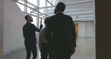 Estate Agent Showing Empty Office Space To Potential Clients