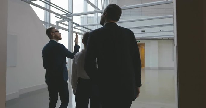 Estate Agent Showing Empty Office Space To Potential Clients