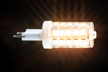 Glowing energy saving G9 led lamp with a dark background