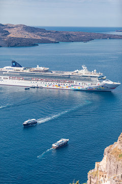 Santorini, Greece - 10.10.2019: Norwegian Star is a cruise ship owned and operated by Norwegian Cruise Line in Santorini bay in Greece. Bringing tourist to summer vacation. Sea transportation