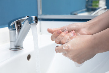 Woman washing hands carefully with soap and sanitizer, close up. Prevention of pneumonia virus spreading, protection against coronavirus pandemia. Hygiene, sanitary, cleanliness, disinfection. Safety.