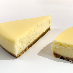 Bright pieces of cheesecake on white pink background