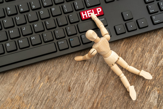 Wooden Dummy Pressing HELP Button On A Computer Keyboard