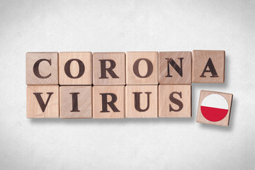 Wooden blocks with flag of Poland and letters spelling CORONAVIRUS on white paper texture background. Novel Coronavirus (2019-nCoV) concept, for an outbreak occurs in Poland.