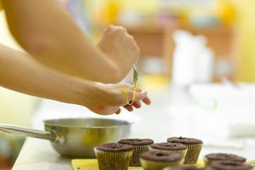 Obraz na płótnie Canvas The process of making chocolate cupcakes with sweet cream. Creation of cakes by professional pastry chefs