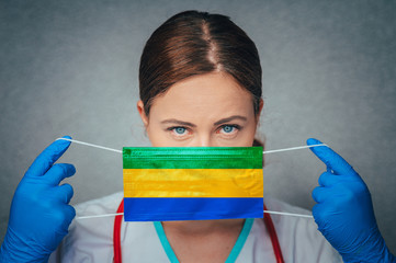 Coronavirus in Gabon Female Doctor Portrait hold protect Face surgical medical mask with Gabon...