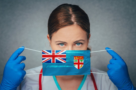 Coronavirus in Fiji, Female Doctor Portrait hold protect Face surgical medical mask with Fiji National Flag. Illness, Virus Covid-19 n Fiji, concept photo