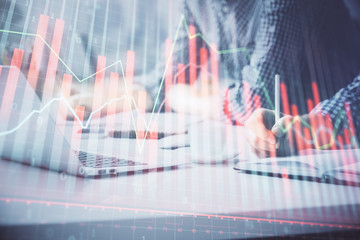 Multi exposure of forex chart with man working on computer on background. Concept of market...