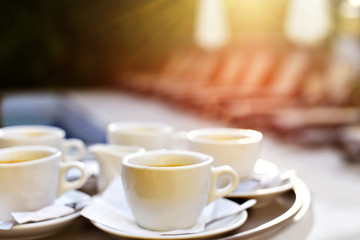 Blurred abstract image out of focus cups of coffee on a table on the street.