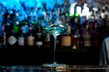 very beautiful glass with blue drink stand on bar counter.