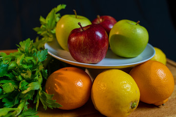 Fototapeta na wymiar Fruta manzana roja y verde, limón y naranja, apio y jengibre