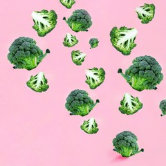 Flying green broccoli slices on a pink background. Concept of flying food, green vegetables, diet food, veggies pattern, food blog.Square with copy space for text.
