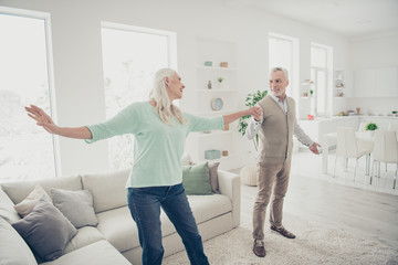Obraz premium Full size photo of charming passionate couple moving enjoying wearing jeans denim trousers teal brown sweater in light big apartment