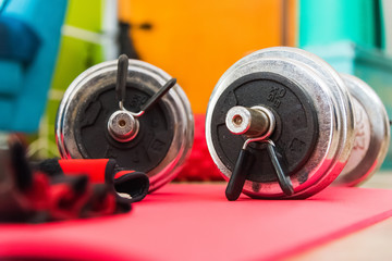 Two dumbbells on a yoga mattress seen from the ground