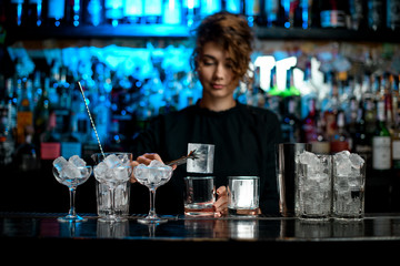 different glasses with ice stand on bar counter.