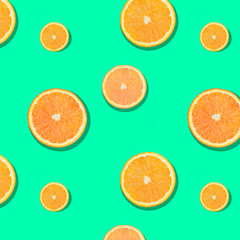 Beautiful trendy pattern oranges on a mint green background. Vitamin concept.
