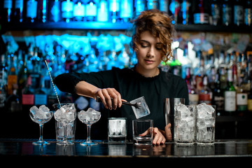 Many glasses with ice stand on bar counter