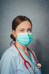 Protection against contagious disease, coronavirus. Female doctor wearing hygienic face surgical medical mask to prevent infection, respiratory illness as flu, 2019-nCoV. Studio photo black background