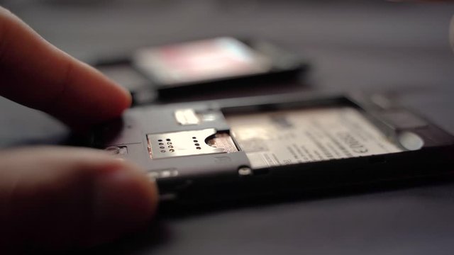 Employees are removing the Micro - sim card, given in the store for customers to buy, male hands 4K.