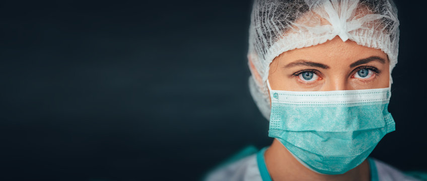 Protection Against Contagious Disease, Coronavirus. Female Doctor Wearing Hygienic Face Surgical Medical Mask. Banner Panorama Medical Staff Preventive Gear. Studio Photo, Black Edit Space