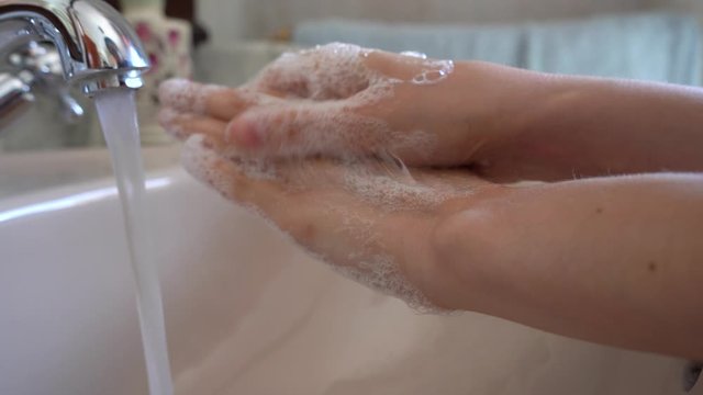 Coronavirus pandemic prevention wash hands with soap warm water rubbing fingers washing frequently.