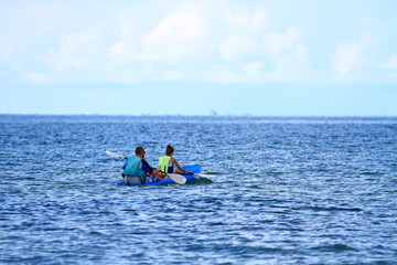 Fototapeta na wymiar 2 tourists kayaking in the sea for relaxation