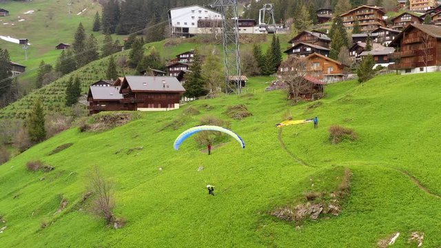 Paraglider launching above Lauterbrunnen valley in the Swiss Alps