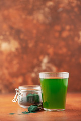 Glass of spirulina drink powder on table. Food and drink, dieting and nutrition concept.
