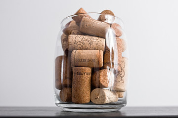 Wine corks lie in a glass jar