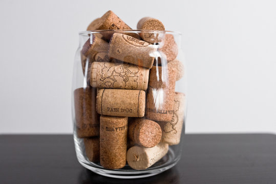 Wine corks lie in a glass jar