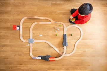 little boy plays with wooden train