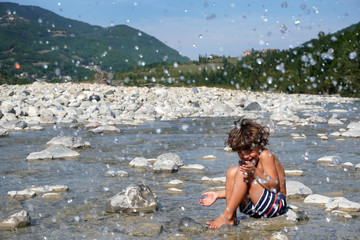  Europe, Italy , Piacenza, Bobbio - children five years old enjoy the nature in the river - summer and holidays during the n-cov19 Coronavirus epidemic        