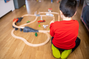 little boy plays with wooden train