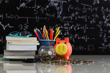 pink piggy bank on top of book with chalkboard .