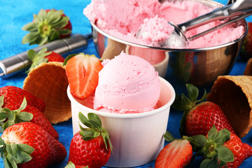 Strawberry ice cream scoop with fresh strawberries and waffle icecream cones