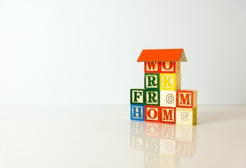Conceptual of work from home during lockdown directives during virus outbreak. Wooden alphabet cubes forming WORK FROM HOME. Focus on selective cubes only.